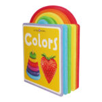 A colorful children's board book titled "colors" with a cover showing a rainbow, a ring stacking toy, and a strawberry, standing upright against a white background.
