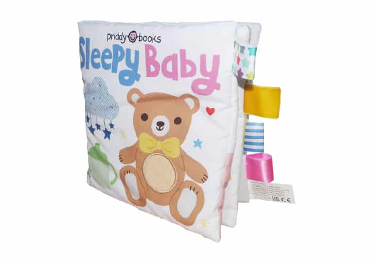 A soft baby book titled "sleepy baby" by priddy books, featuring a plush cover with a brown bear, colorful tags, and baby-themed illustrations on an isolated background.